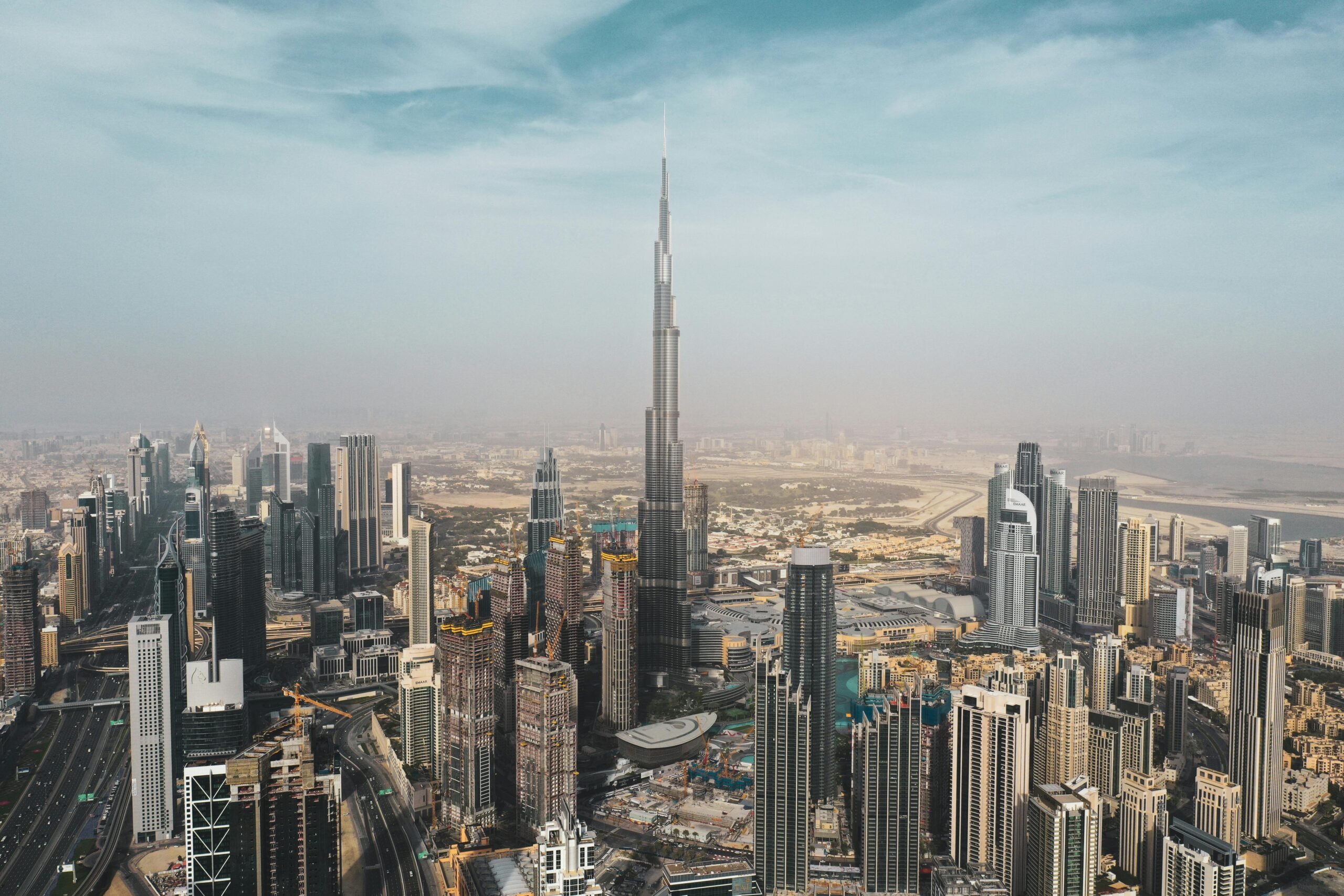 A breathtaking aerial view of Dubai's skyline featuring Burj Khalifa amidst modern skyscrapers under a clear sky.